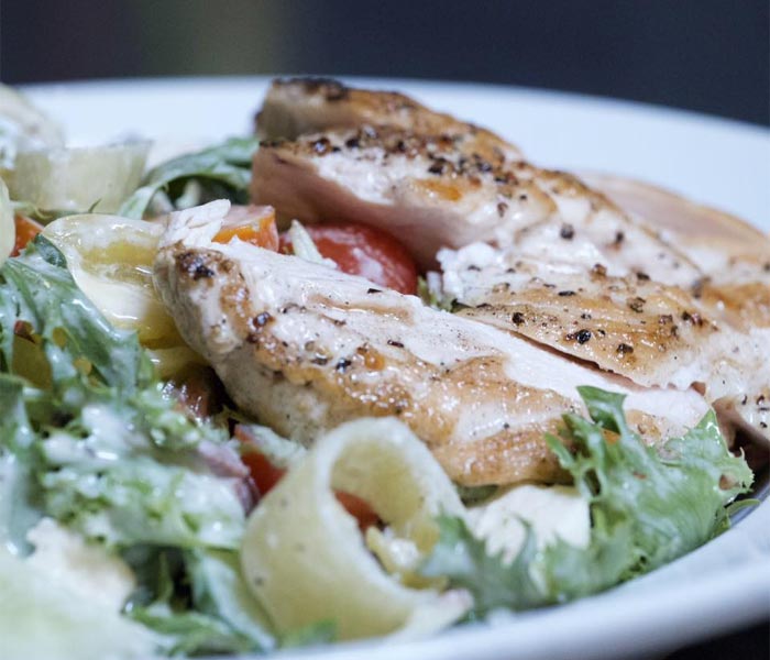 Caesar salad topped with grilled and seasoned chicken breast at DeBlaze at 131 in Carnegie PA