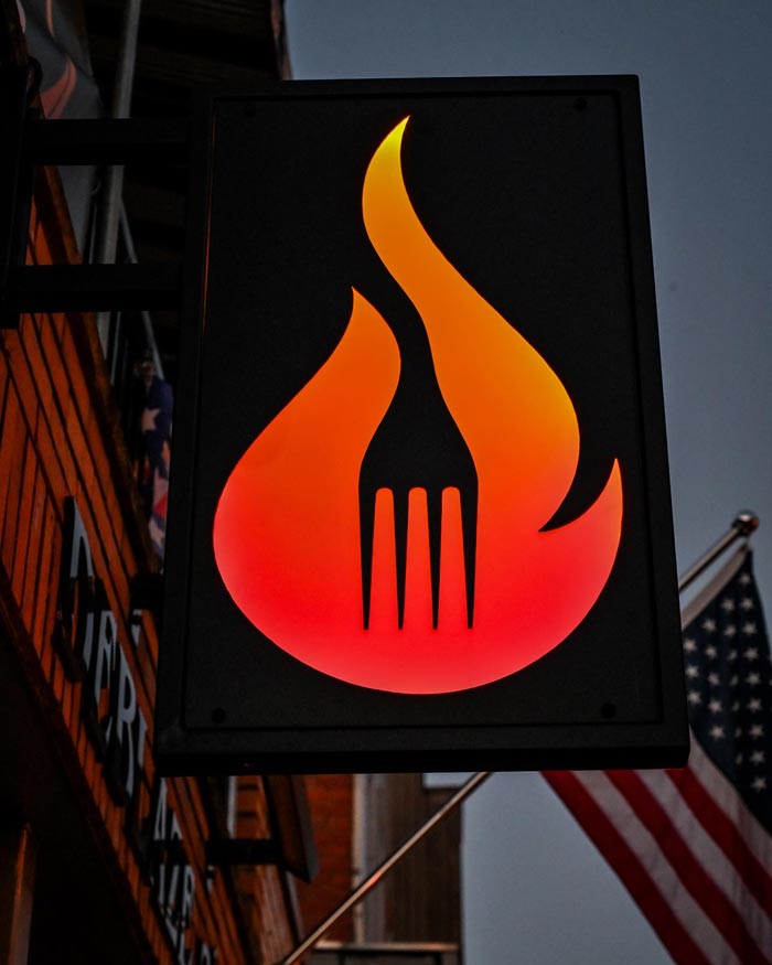 Outdoor signage at DeBlaze at 131 in Carnegie PA of their flame and fork logo
