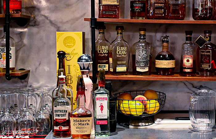 Bottles of liquor and fruit on a bar counter at Carnegie, a renowned steakhouse restaurant.