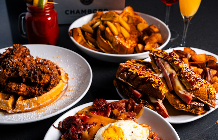 DeBlaze at 131 serves fried chicken, waffles, fries, eggs, and sandwiches on a black table.