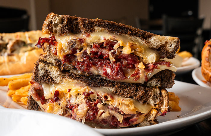 A stacked Reuben sandwich at our steakhouse: corned beef, sauerkraut, cheese on rye bread.