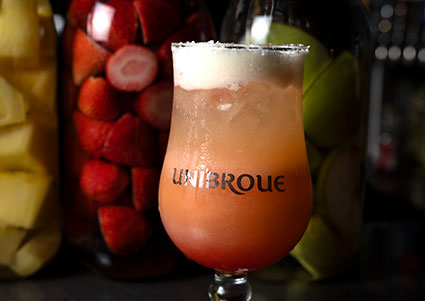 A fruity cocktail in a Unibroue glass, perfect for sipping at an Italian restaurant.