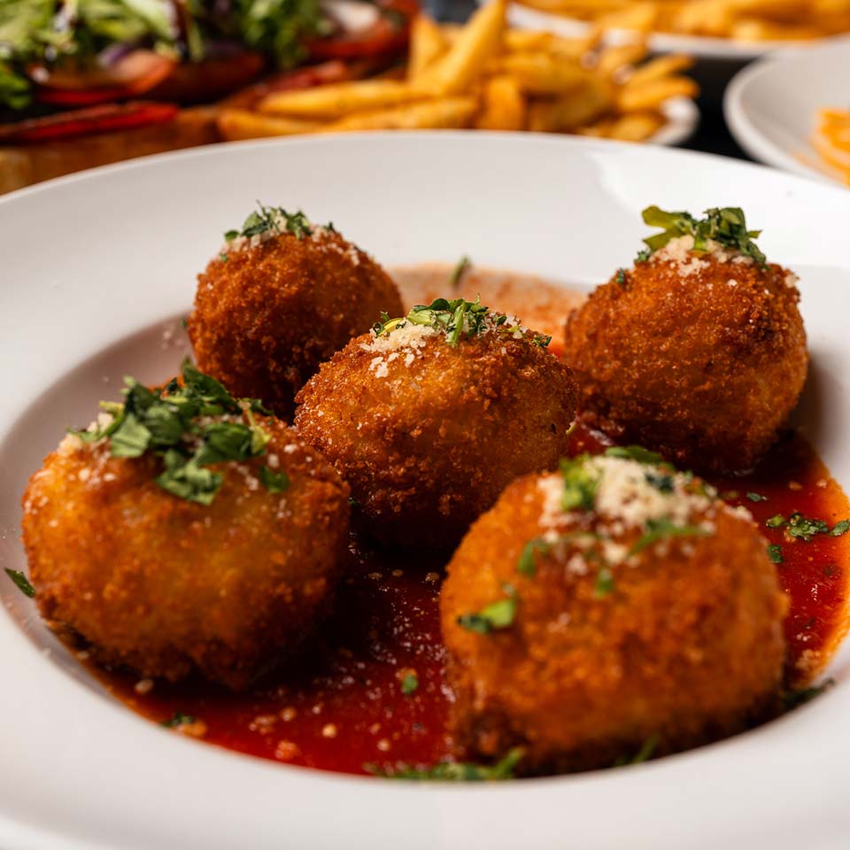 Enjoy five breaded fried balls with herbs on tomato sauce at DeBlaze at 131 Restaurant.